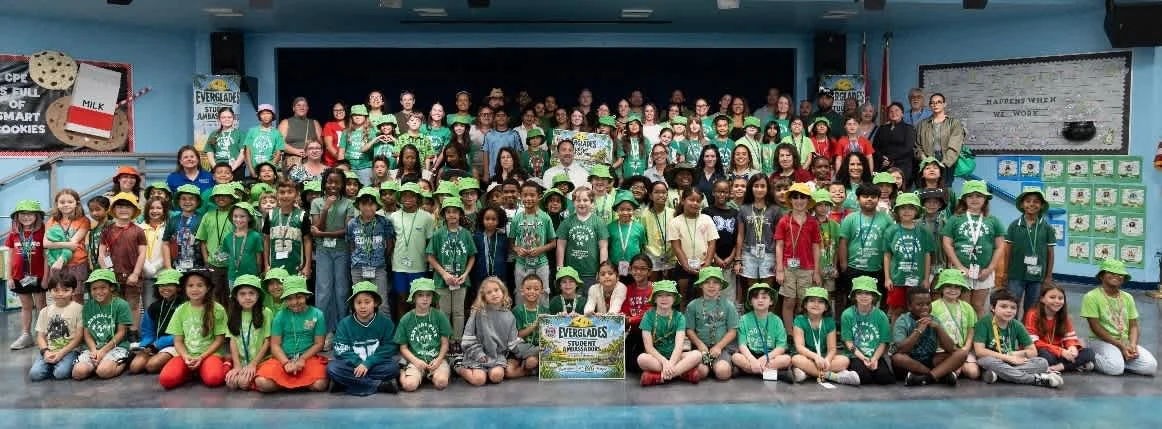 Members of Central Park Elementary's Everglades Ambassadors Club in green hats and shirts in the school's cafeteria in Plantation.