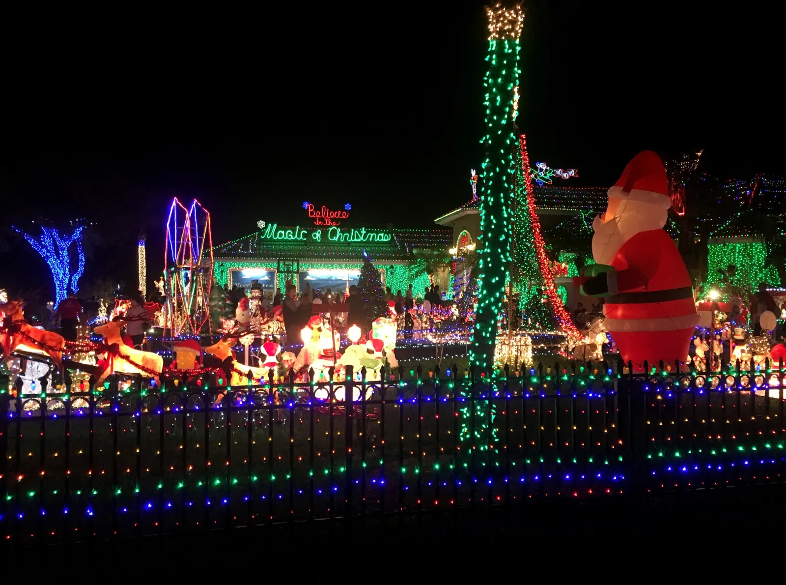 Holiday lights and an inflatable Santa crowd the yard of a Plantation home known for its Christmas display.