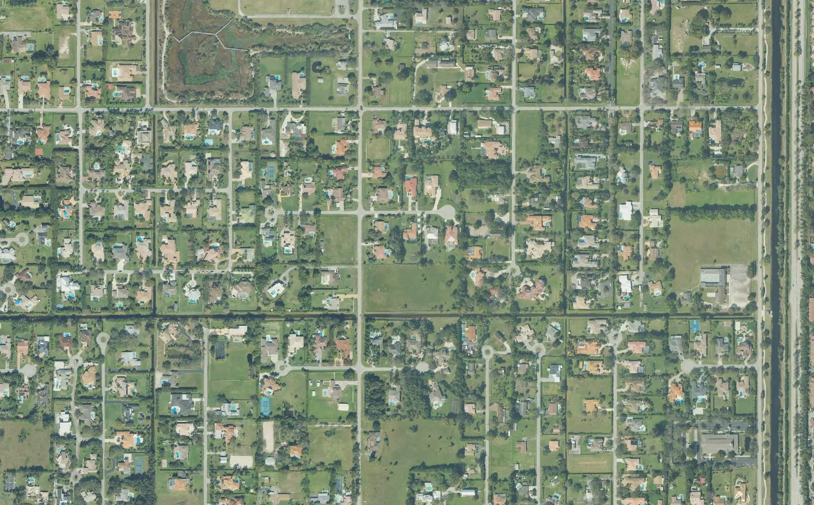 Large lots, pastures and canal-side streets in Plantation Acres, seen from above.