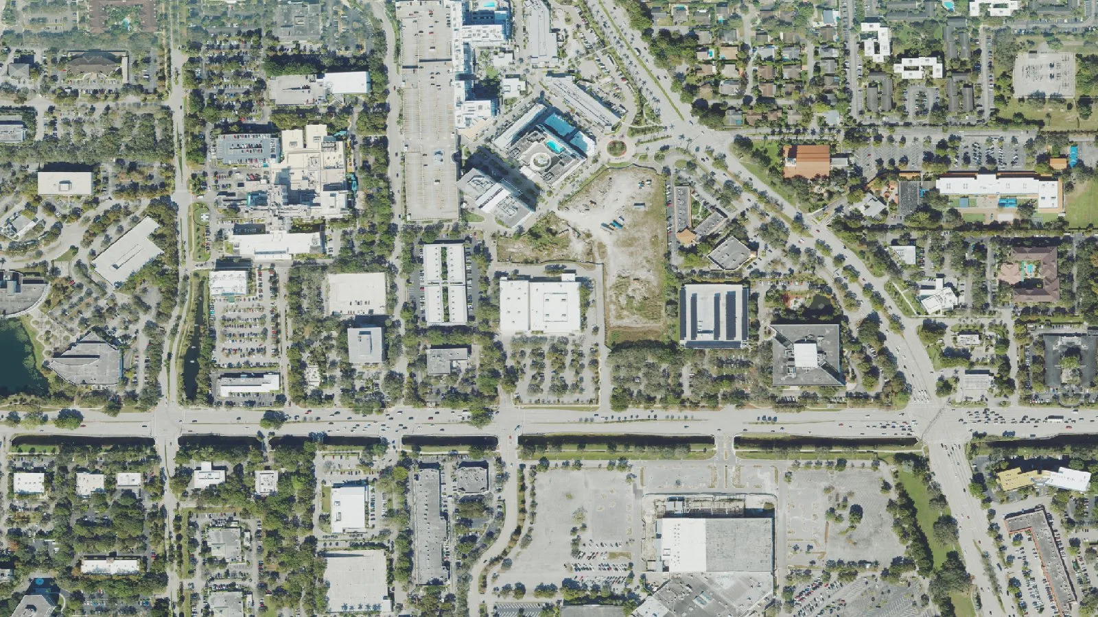 Offices, stores and apartments on both sides of West Broward Boulevard in central Plantation, seen from above.
