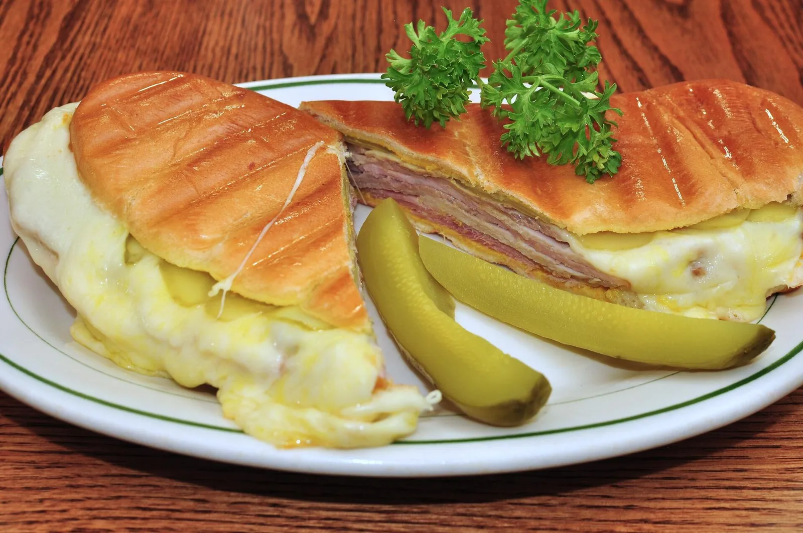 A Cuban sandwich cut in half on a plate.
